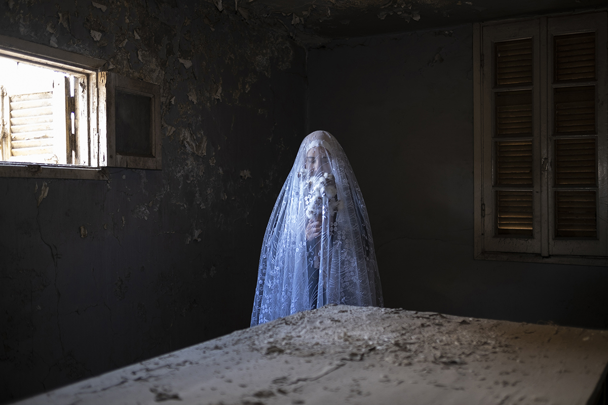 A self portrait taken standing holding a bouquet of cotton flowers covered by veil at my grandmothers old kitchen in our family’s old home, on January 20,2021, El Mehalla El Kobra, Egypt.