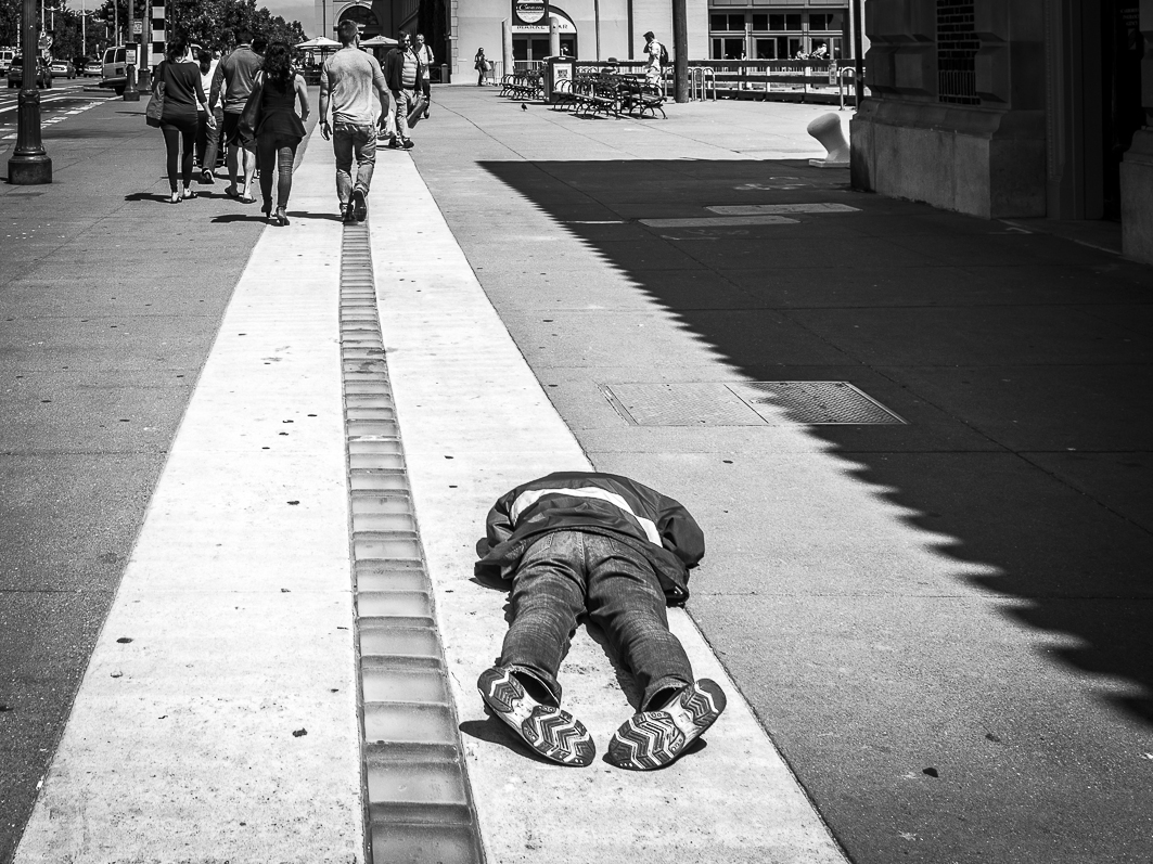 Homeless fainted in the streets of San Francisco and ignored by passers-by on the harbor promenade, the day before the celebration of Independence Day of the United States. San Francisco, California July 3, 2015. © Miguel Cerezo. Homeless desfallecido en las calles de San Francisco e ignorado por los viandantes en el paseo maritimo del puerto, el dia anterior de la celebración del Dia de la Independencia de los Estados Unidos. San Francisco, California. 3 de Julio de 2015.© Miguel Cerezo.